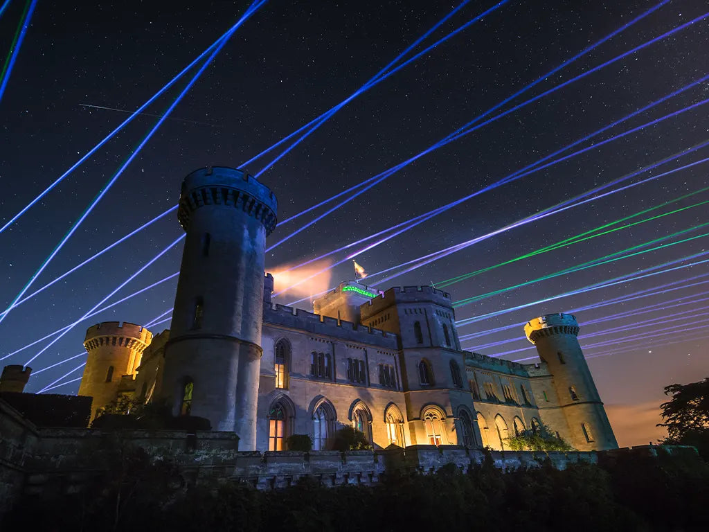 Kvant Spectrum lasers projecting a wide array of beams in the sky over a castle